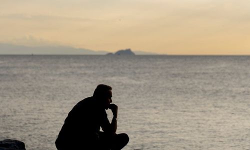 A silhouette of a person sitting peacefully, with lines indicating calm breathing.