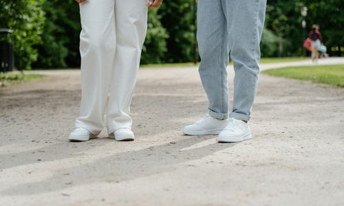 Pair of comfortable walking shoes on a path in a green park.